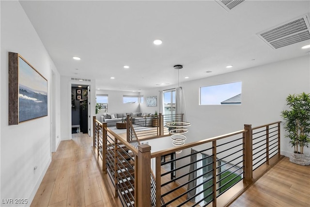 hallway featuring recessed lighting, an upstairs landing, visible vents, and light wood-type flooring