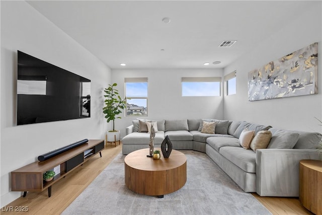 living area with recessed lighting, wood finished floors, and visible vents