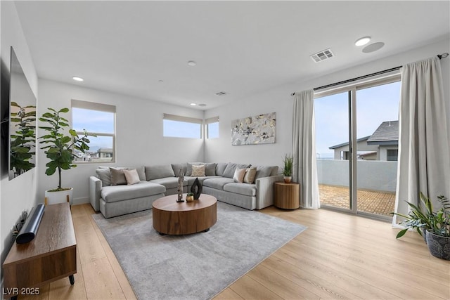 living area featuring light wood finished floors, visible vents, and recessed lighting