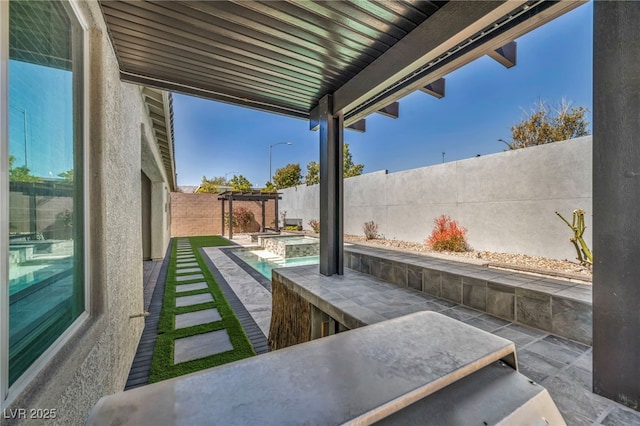 view of patio / terrace with a fenced backyard and a pool with connected hot tub