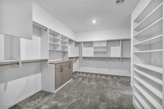 walk in closet with visible vents and dark colored carpet