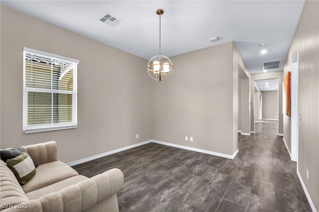 interior space featuring dark wood finished floors, visible vents, a notable chandelier, and baseboards