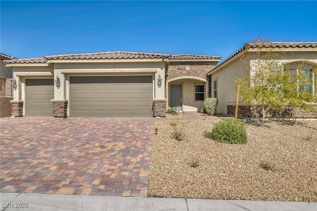 view of front of home featuring decorative driveway, stone siding, an attached garage, and stucco siding