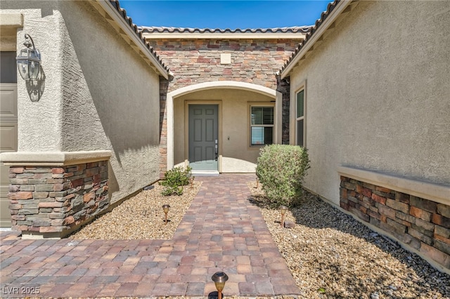 entrance to property featuring stucco siding and stone siding