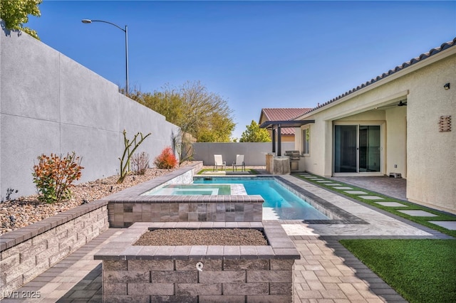 view of pool with a fenced in pool, an outdoor kitchen, an in ground hot tub, area for grilling, and a fenced backyard