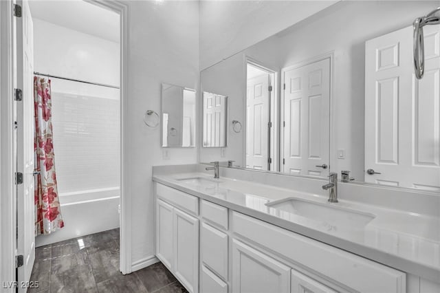 bathroom featuring double vanity, shower / tub combo, and a sink