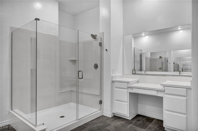 full bath with vanity, a stall shower, and wood tiled floor