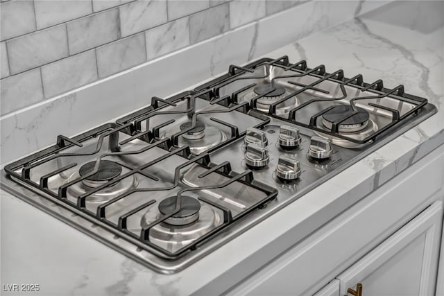 room details featuring backsplash and stainless steel gas cooktop