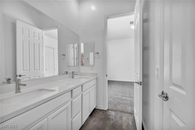 full bath featuring a sink, visible vents, wood finished floors, and double vanity