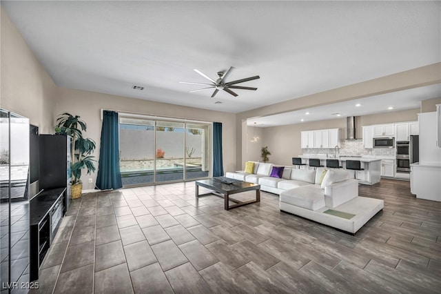 living room with dark wood-type flooring, recessed lighting, a ceiling fan, and visible vents