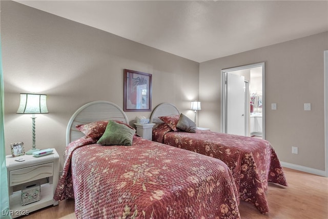 bedroom featuring baseboards and wood finished floors