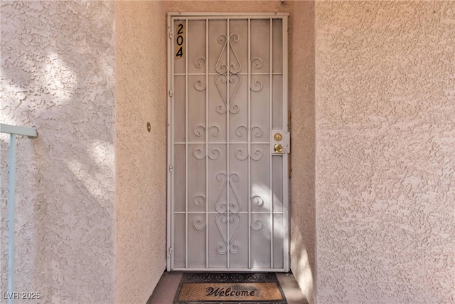 view of exterior entry featuring stucco siding