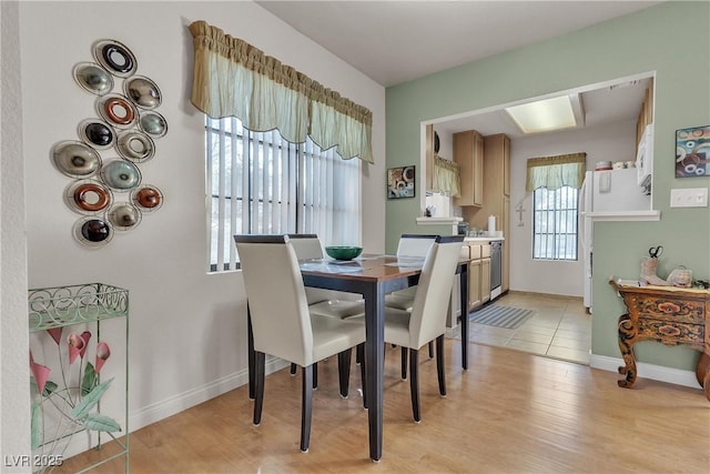 dining area with light wood-style flooring and baseboards