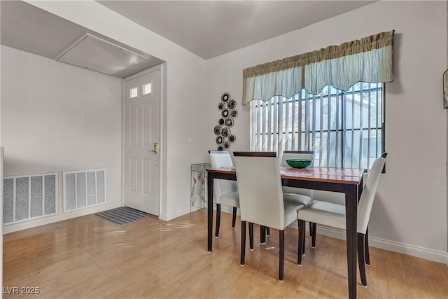 dining room with visible vents, baseboards, and wood finished floors