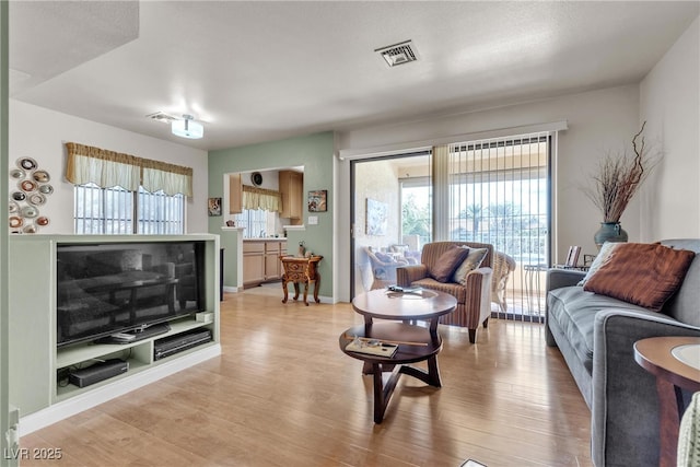 living area featuring visible vents and light wood-style floors