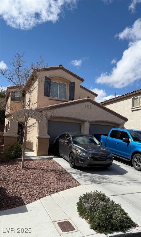 view of front of property featuring a garage, concrete driveway, and stucco siding