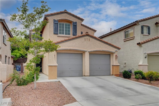 mediterranean / spanish-style house featuring stucco siding, concrete driveway, a tiled roof, and fence