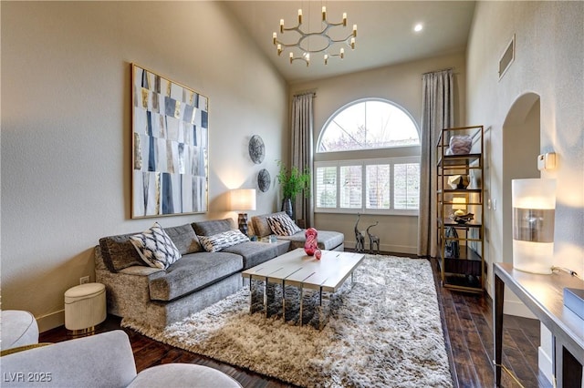 living area with visible vents, baseboards, a notable chandelier, and dark wood-style flooring