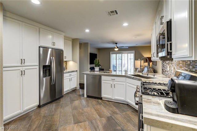 kitchen featuring visible vents, a sink, tasteful backsplash, appliances with stainless steel finishes, and white cabinets