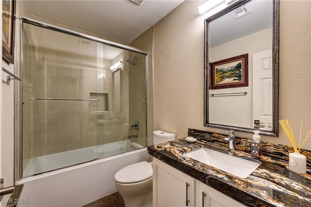 full bath featuring visible vents, toilet, combined bath / shower with glass door, vanity, and a textured wall