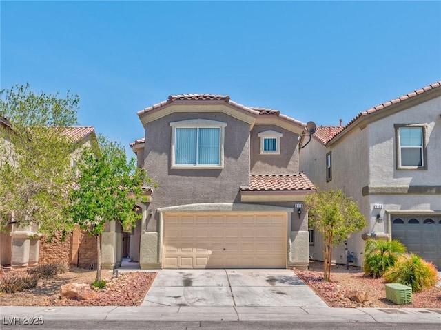 mediterranean / spanish house with stucco siding, a garage, driveway, and a tiled roof