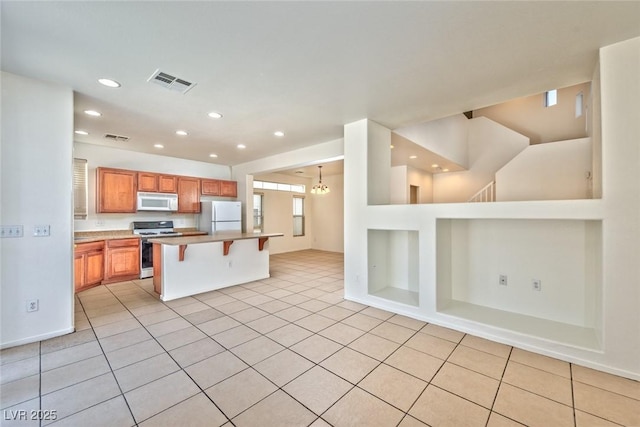 kitchen with visible vents, white appliances, and open floor plan