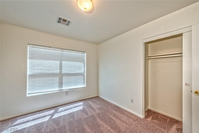 unfurnished bedroom with carpet, visible vents, a closet, and baseboards