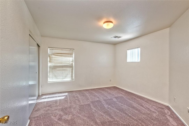 spare room featuring visible vents, baseboards, and carpet floors