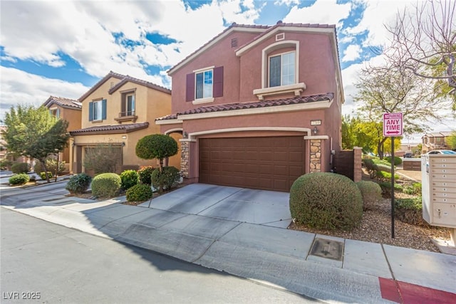 mediterranean / spanish house with stucco siding, concrete driveway, an attached garage, and a tiled roof