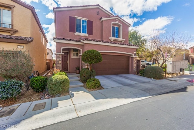 mediterranean / spanish-style home with stucco siding, concrete driveway, a tile roof, and a garage