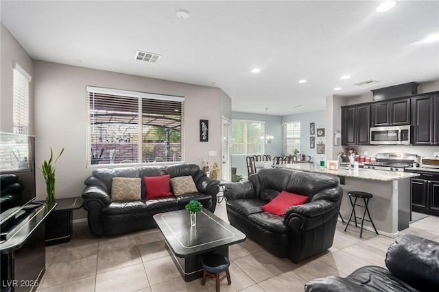 living area with recessed lighting, visible vents, and light tile patterned floors