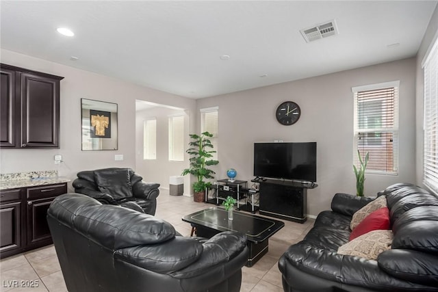 living room featuring light tile patterned floors and visible vents