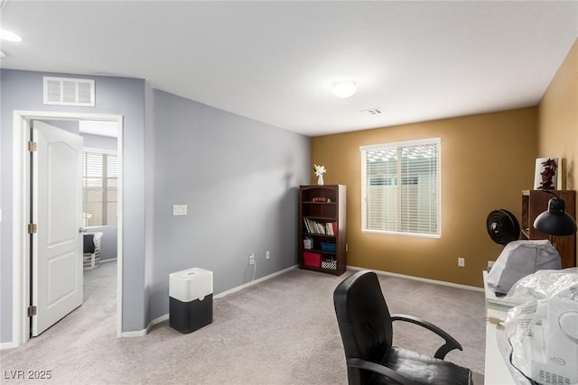 home office featuring light colored carpet, baseboards, visible vents, and a wealth of natural light