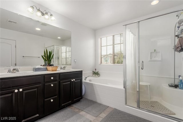 bathroom featuring a bath, a stall shower, and a sink