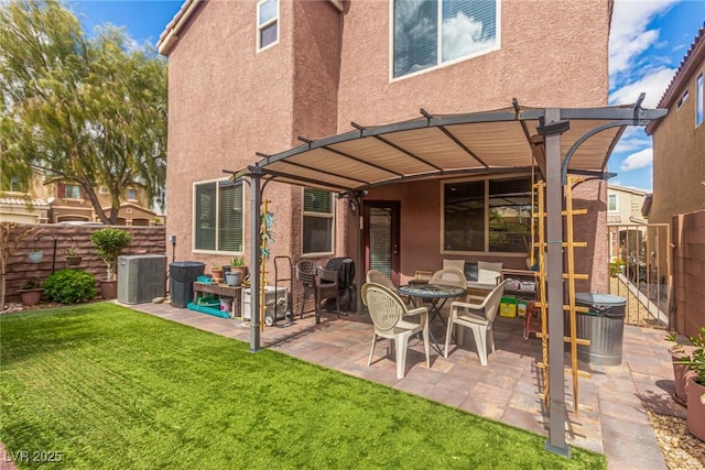 back of property with a fenced backyard, stucco siding, a pergola, and a yard