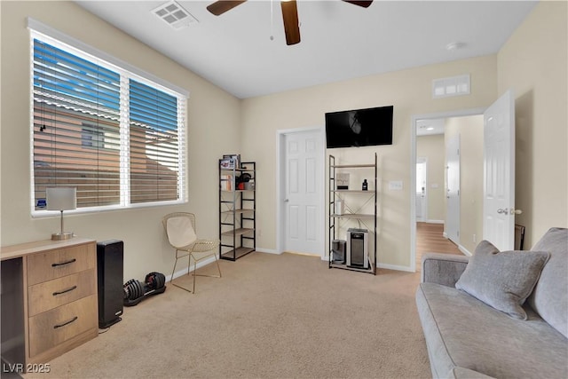 sitting room featuring ceiling fan, baseboards, visible vents, and light carpet