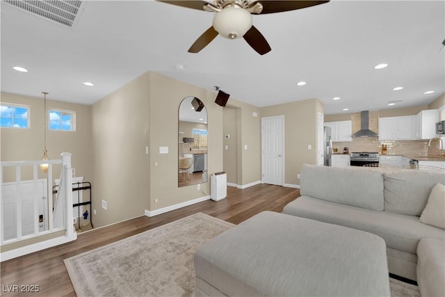 living room featuring recessed lighting, visible vents, baseboards, and wood finished floors