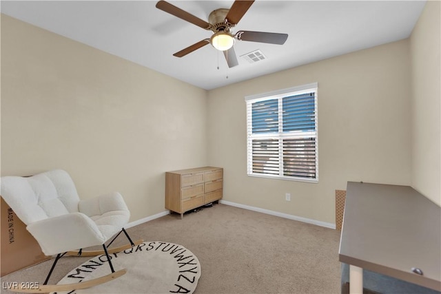 living area featuring visible vents, light colored carpet, baseboards, and ceiling fan