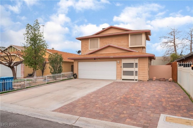 view of front facade featuring driveway, a garage, and fence