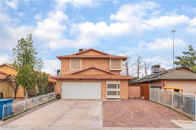 view of front facade with central air condition unit, concrete driveway, a garage, and fence