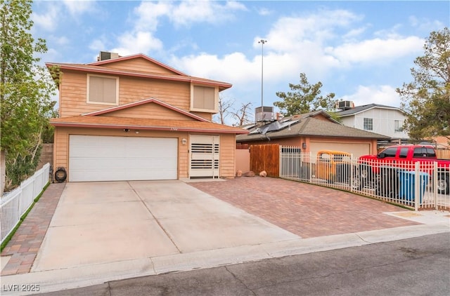 view of front of property featuring central air condition unit, an attached garage, decorative driveway, and fence