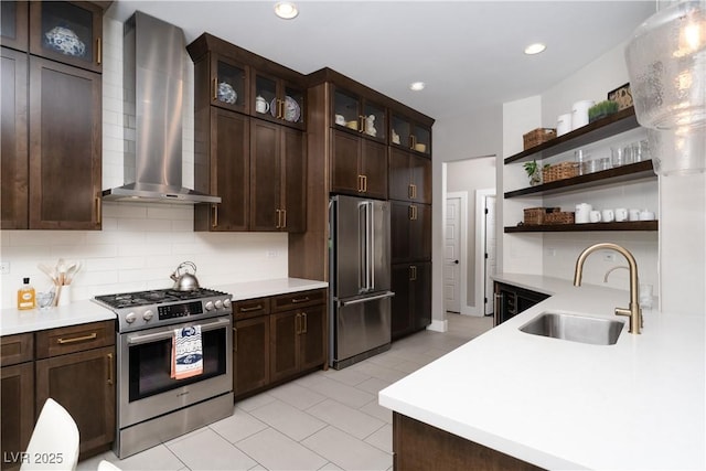 kitchen featuring a sink, tasteful backsplash, appliances with stainless steel finishes, and wall chimney exhaust hood