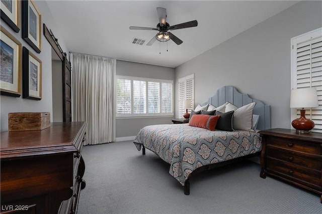 carpeted bedroom featuring visible vents, a barn door, baseboards, and ceiling fan