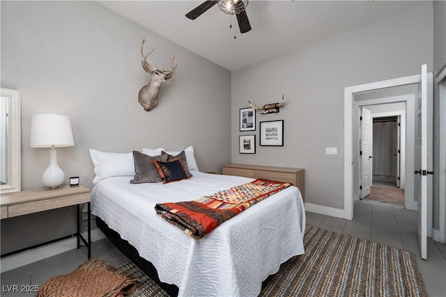 tiled bedroom with baseboards and a ceiling fan