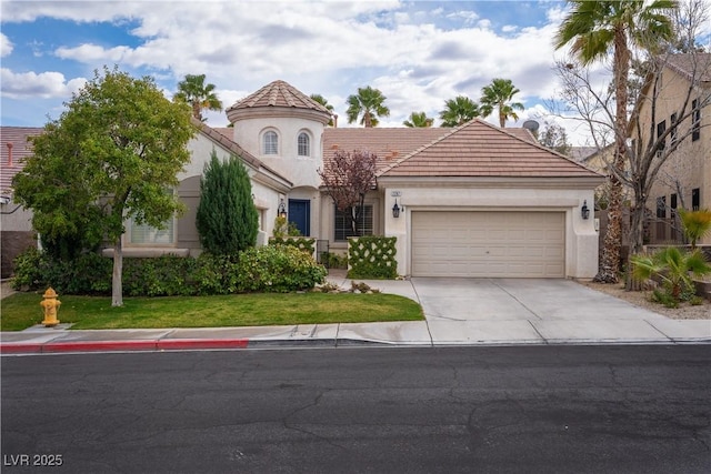 mediterranean / spanish house featuring a front yard, an attached garage, stucco siding, concrete driveway, and a tiled roof