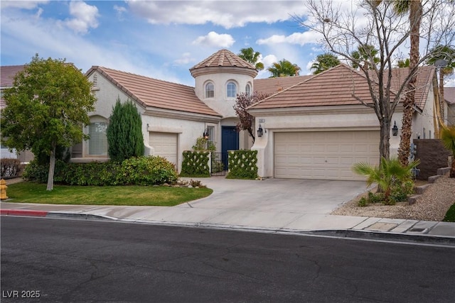 mediterranean / spanish home with concrete driveway, a tiled roof, an attached garage, and stucco siding