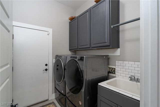 washroom featuring a sink, cabinet space, and washer and clothes dryer