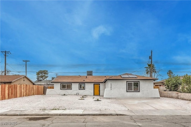 single story home with a patio area, a fenced backyard, roof mounted solar panels, and stucco siding