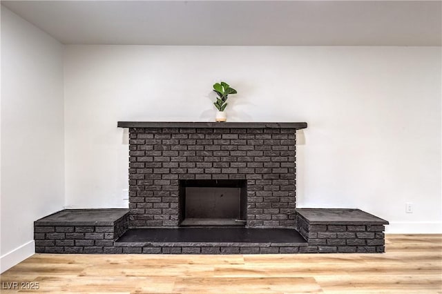 details with a brick fireplace, baseboards, and wood finished floors