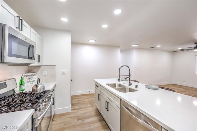 kitchen featuring a sink, light countertops, tasteful backsplash, and stainless steel appliances